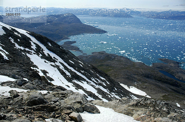 Weiter Blick über Schneefelder auf Eisberge und Berge Sermilik Fjord Ostgrönland