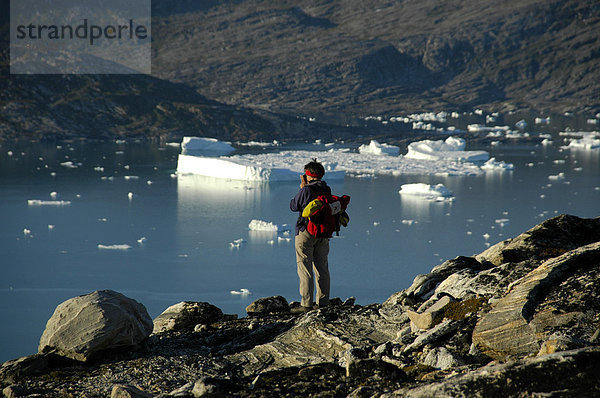 Frau fotografiert Fjord mit Eisbergen und Berge Nagtivit Kangertivat Fjord Ostgrönland