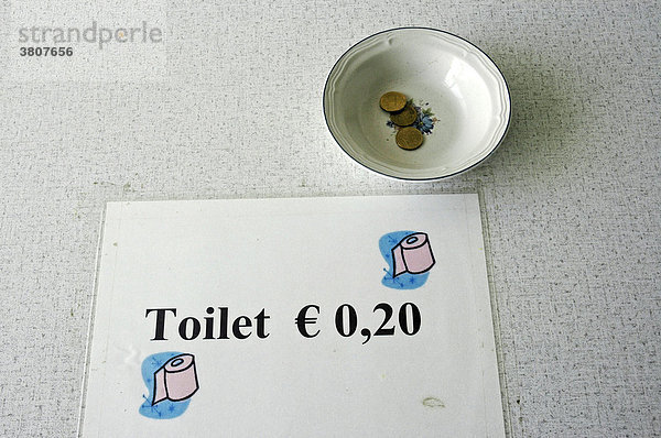 Hinweis und Schale mit Geld für die Toilettenbenutzung