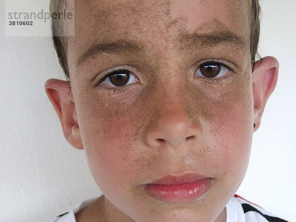 Porträt eines erschöpften Jungen mit sandigem Gesicht