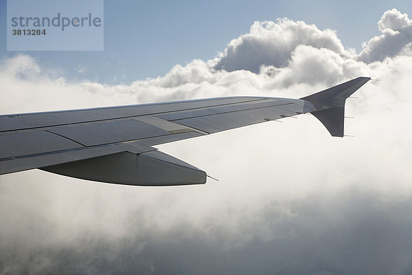 Tragfläche von Flugzeug über Wolken
