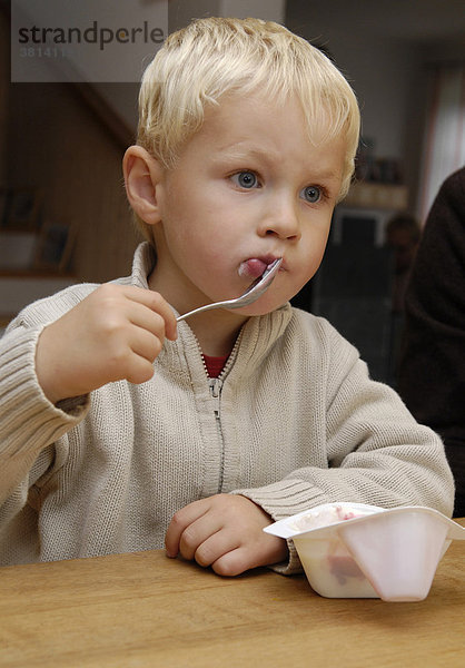 Junge isst Joghurt