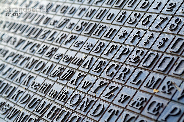 Buchstaben und Zahlen aus Guss als Bodenbelag auf einem Marktpaltz in England