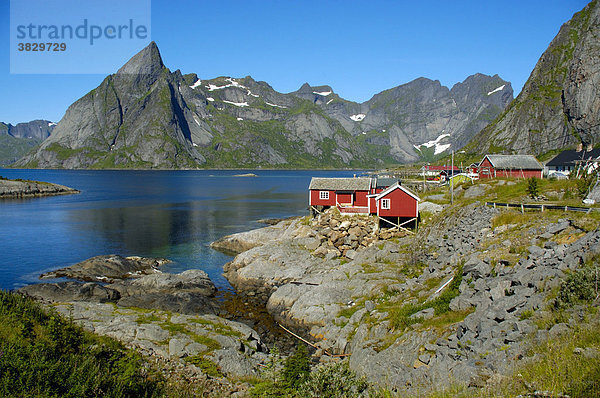 Rotes Holzhaus Berge und Fjord Hanmöya Moskenesöya Lofoten Norwegen Holzhaus