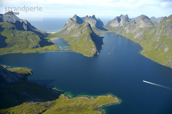 Spitze Berge mit Fjord Kjerkfjorden und Boot Moskenesöya Lofoten Norwegen