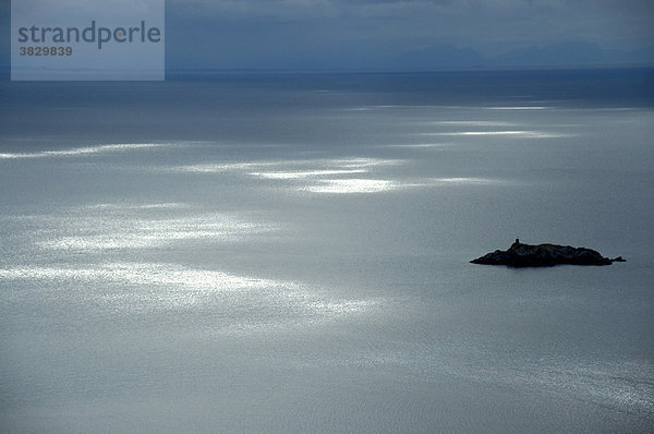 Einzelne Sonnenflecken auf dem offenen Meer mit einer Insel Lofoten Norwegen