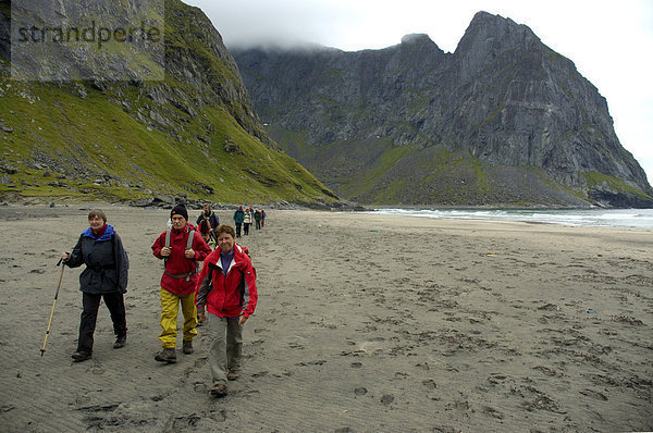 MR Gruppe Wanderer auf Sandstrand Kvalvika Bucht Moskenesöya Lofoten Norwegen