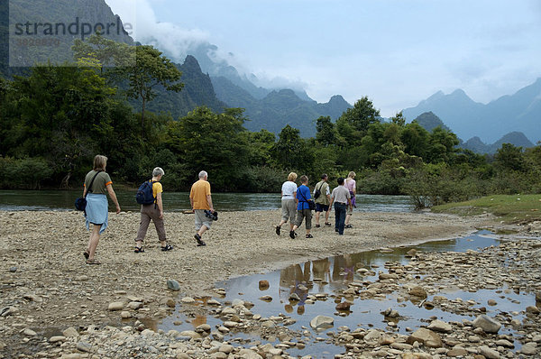 Gruppe Touristen wandert am Fluß bei Vang Vieng Laos