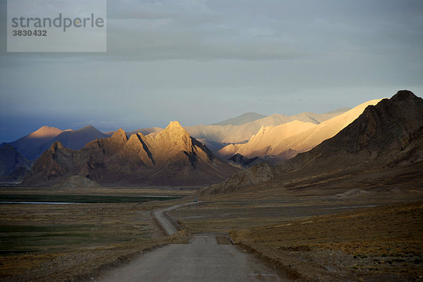 Weite Wildnis mit Alpenglühen auf den Bergen hinter Straße bei Old Tingri Tibet China