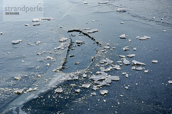 Wieder zugefrorenes Eisloch im See  gefrorenes Eis auf einem See