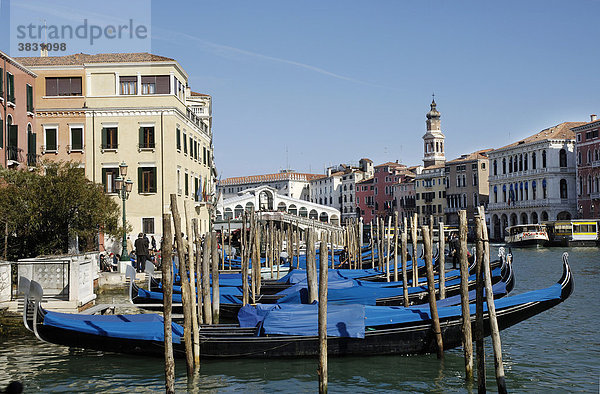 Blau zugedeckte Gondeln am Canale Grande mit Rialto Brücke im Hintergrund in Venedig Italien