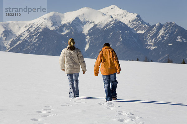Frau mit jungem Mann in einer verschneiten Winterlandschaft