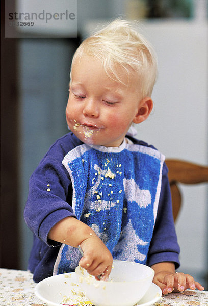 Einjähriger ißt stolz sein Müsli