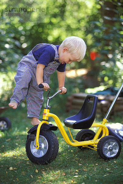 Zwei Jahre alter Junge turnt am Dreirad