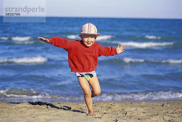 Dreiähriger Junge läuft am Strand