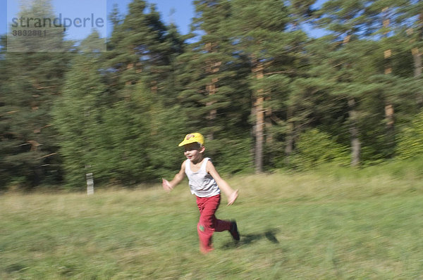 Sechs 6 Jahre alter Junge läuft mit ausgebreiteten Armen im Perlacher Forst in München Bayern Deutschland