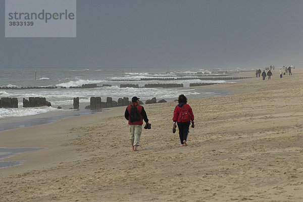 Spaziergänger bei schlechtem Wetter am Strand von Westerland auf Sylt  Schleswig Holstein  Deutschland