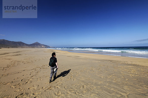 Frau mit Rucksack läuft an Playa de Cofete  Jandia   Fuerteventura   Kanarische Inseln