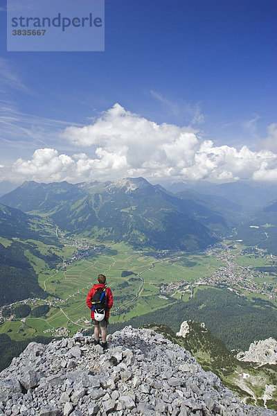 Bergsteiger auf der Sonnenspitze mit Blick auf Ehrwald und Lermoos