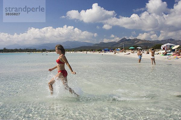 Frau läuft ins Wasser am Strand Cala Brandinchi Ostküste Sardinien