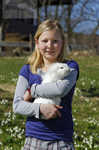 Mädchen hält ein Kaninchen auf dem Arm