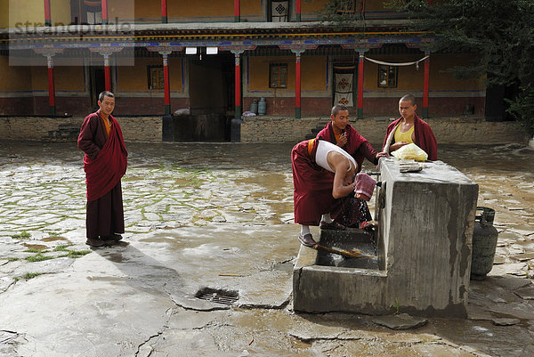 Junge tibetische Mönche bei der Morgenwäsche im Hof vom Kloster Mindroling  Tsetang  Tibet  China  Asien
