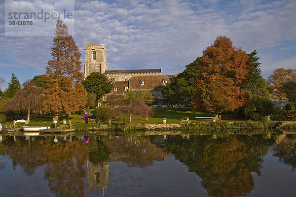 Herbstlicher Blick auf Fluss mit St. Mary's Kirche und Bäumen am Ufer  Frome Fluss  Wareham  Dorset  England  Großbritannien  Europa