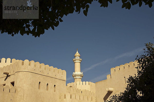 Blick auf das Fort von Nizwa mit dem Minarett der Sultan Quaboos Moschee  Oman  Naher Osten