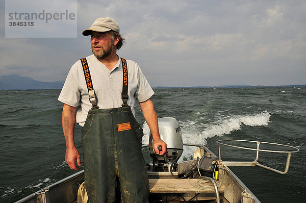 Chiemsee-Fischer Thomas Lex auf seinem Fischerboot nahe der Fraueninsel  Chiemsee  Chiemgau  Bayern  Deutschland  Europa