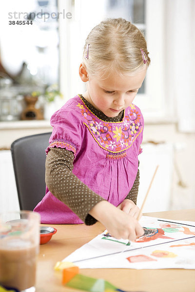 Ein Mädchen malt mit Wasserfarben