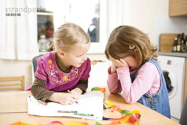 Zwei Mädchen beim Malen mit Stiften  ein Mädchen weint
