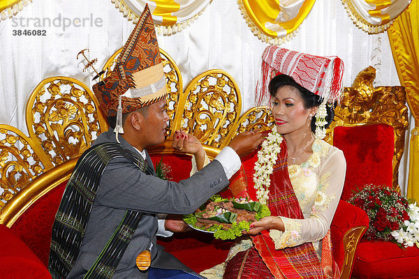 Brautpaar  traditionelles gegenseitiges Füttern  Hochzeitszeremonie  Siantar  Batak Region  Sumatra  Indonesien  Asien