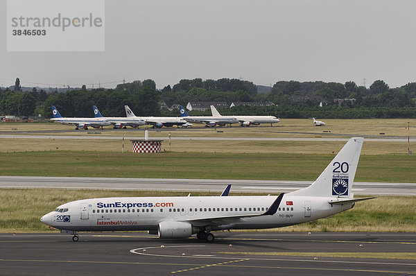 SunExpress Boeing 737- 800 auf dem Rollfeld  hinten weitere Flugzeuge  Flughafen Düsseldorf international  Nordrhein-Westfalen  Deutschland  Europa