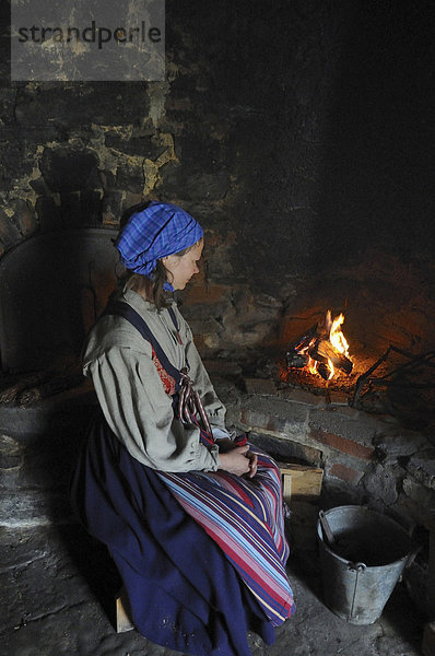 Frau am alten Ofen in einem Museum  Östarp  SkÂne  Schweden  Europa