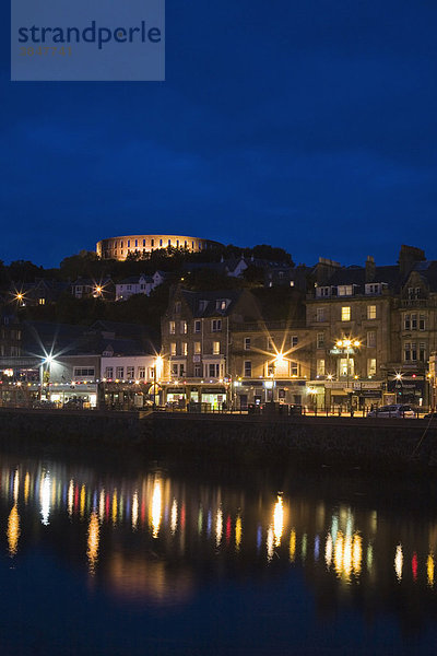 Oban mit der Hafenpromenade und dem McCaig's Tower bei Nacht  Argyll  Schottland  Großbritannien  Europa