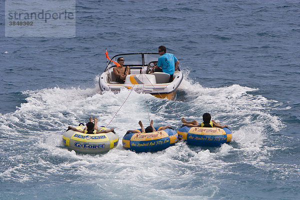 Jugendliche in Schwimmreifen gezogen von einem Motorboot vor dem Strand der Promenade des Anglais in Nizza  CÙte d'Azur  Südfrankreich  Frankreich  Europa