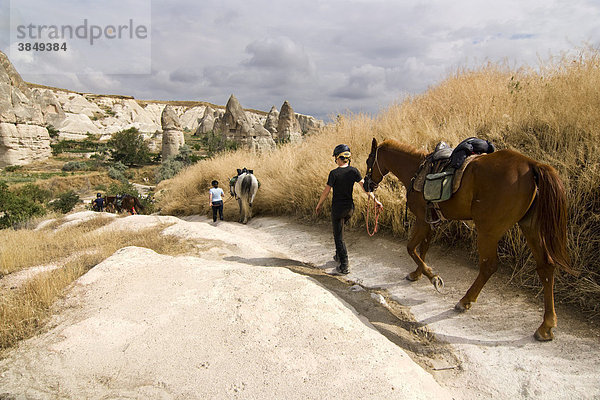 Reiter mit Pferden wandern durch die Tuffsteinlandschaft des UNESCO Weltkulturerbes Göreme  Kappadokien  Zentralanatolien  Türkei  Asien