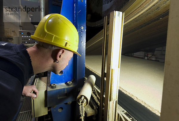 Ein Mitarbeiter beobachtet den Produktionsprozess der Spanplatten an der Presse der Produktionsstraße  Werk der Pfleiderer AG am Unternehmenssitz in Neumarkt  Oberpfalz  Bayern  Deutschland  Europa