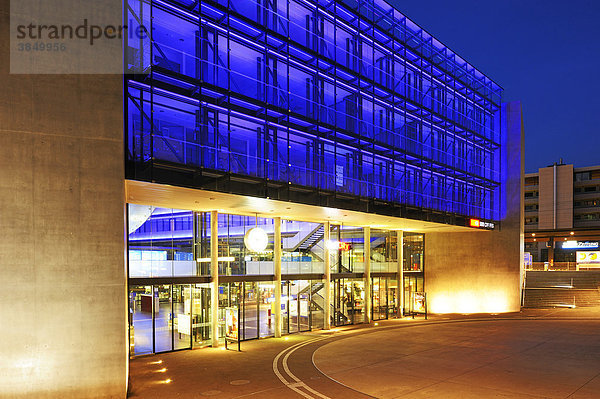 Mit farbigem Neonlicht beleuchtete Glasfassade des Bahnhofs Zug  Schweiz  Europa