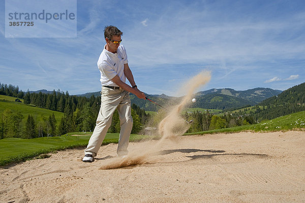 Golfspieler im Bunker schlägt Ball aus Sand  auf Alpingolfplatz  Achenkirch  Tirol  Österreich  Europa