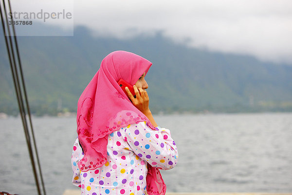 Muslimische junge Frau mit Handy  Insel Samosir  Tobasee  Batak Region  Sumatra  Indonesien  Asien
