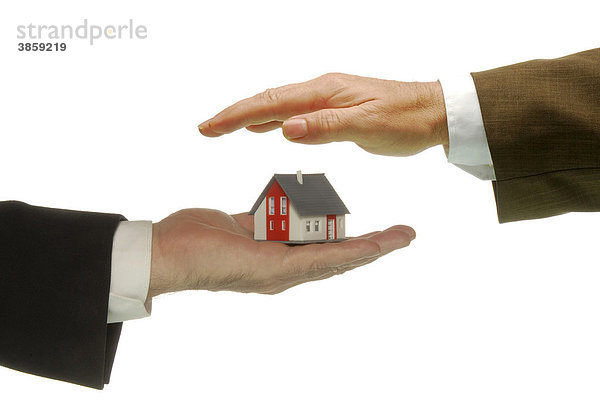Eine Hand hält ein Haus  die andere schützt es  Symbolbild für Schutz von Immobilien