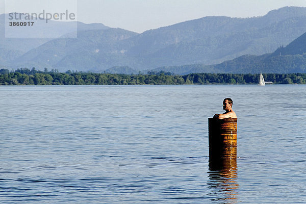 Mann in einem Metall-Fass auf dem Chiemsee  Chiemgau  Oberbayern  Bayern  Deutschland  Europa