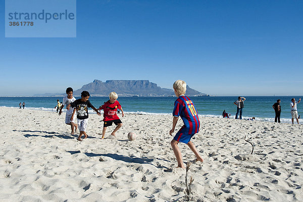 Kinder spielen Fußball am Strand von Bloubergstrand  hinten der Tafelberg  Kapstadt  Südafrika  Afrika