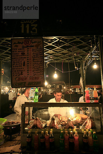 Garküche bietet Schaf an  auch gekochten Schafskopf  Djemaa-el-Fna  Platz der Gehängten in der Medina von Marrakesch  in der Abenddämmerung  Marokko  Afrika