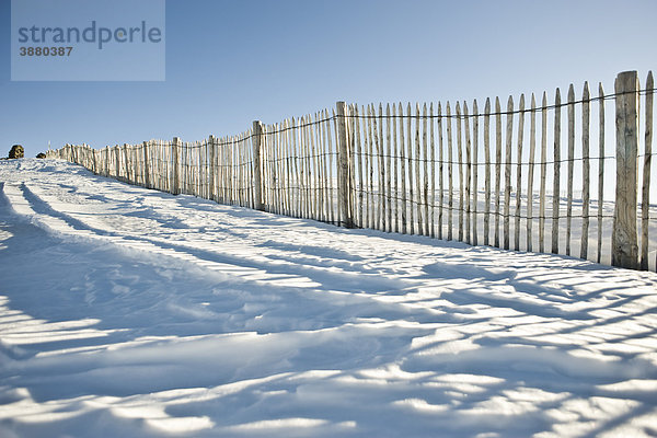 Zaunlinie im schneebedeckten Feld