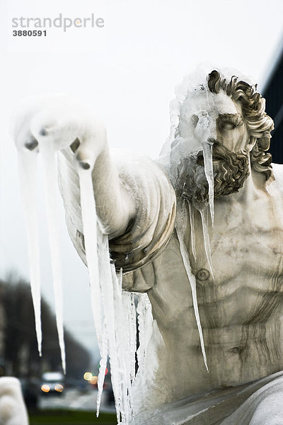 Statue einer wilden männlichen Figur  die in die Ferne zeigt  Gesicht von Eiszapfen verdeckt.