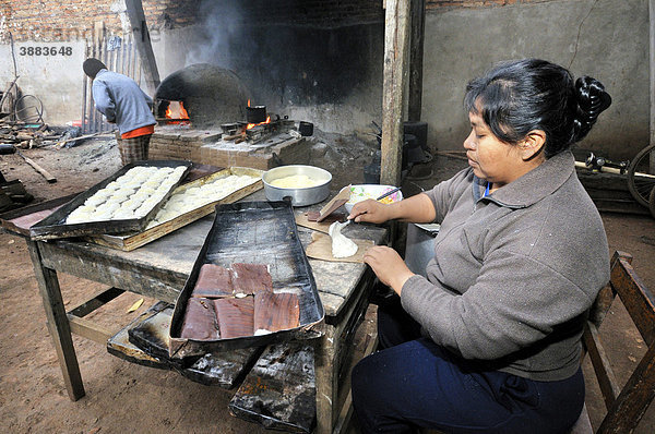 Bäckerin in Hinterhofbäckerei im Morgengrauen bereitet Brötchen zum Backen im traditionellen Holzofen vor  San Ignacio  Chiquitania  Departamento Santa Cruz  Bolivien  Südamerika