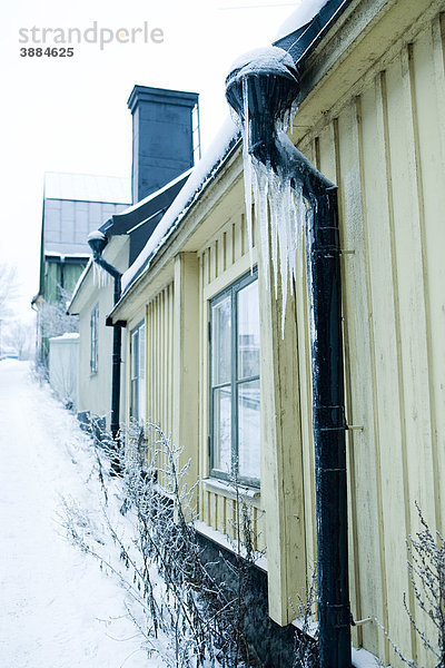 Eiszapfen hängend an der Dachrinne am Haus