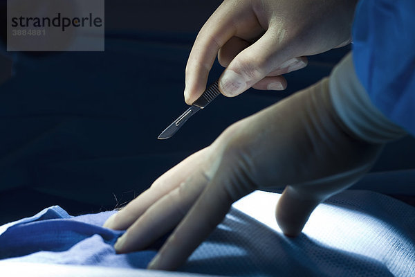 Skalpell in der Hand des Chirurgen zu Beginn des chirurgischen Eingriffs